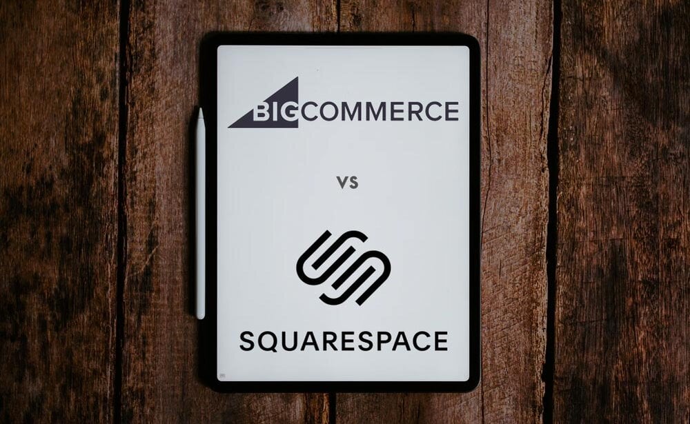 Bigcommerce vs Squarespace - the two logos on different sides of a notebook