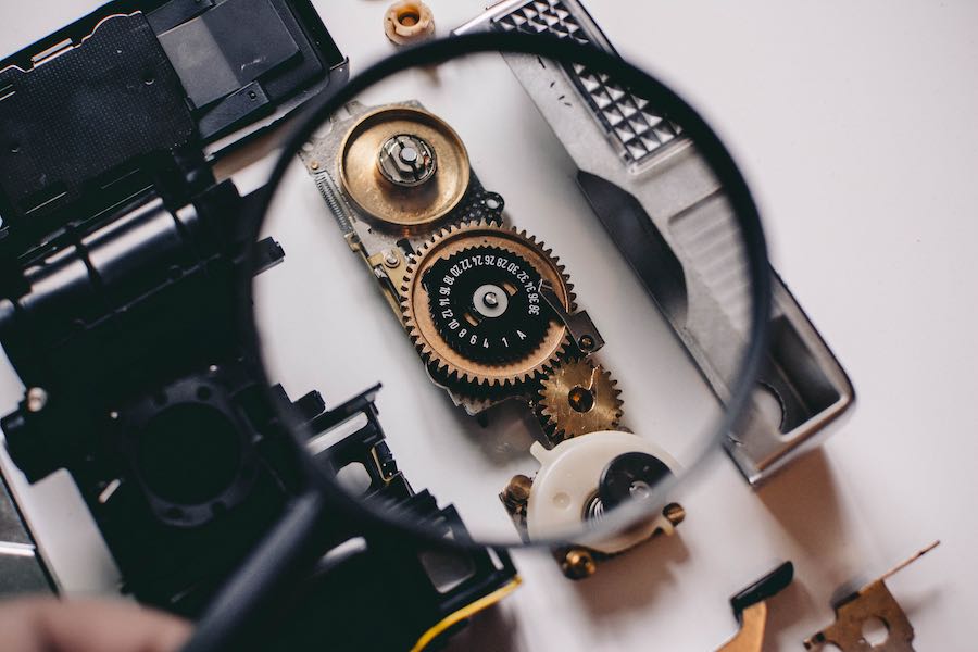 Due diligence (image of a magnifying glass revealing inner workings of a device)