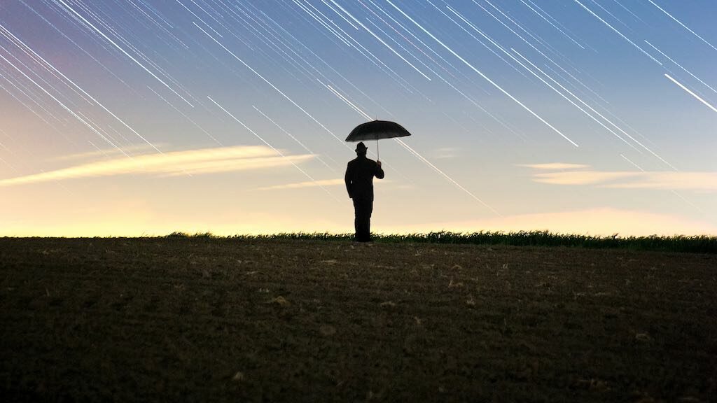 Business insurance policies are important to startups (image of a man with an umbrella).