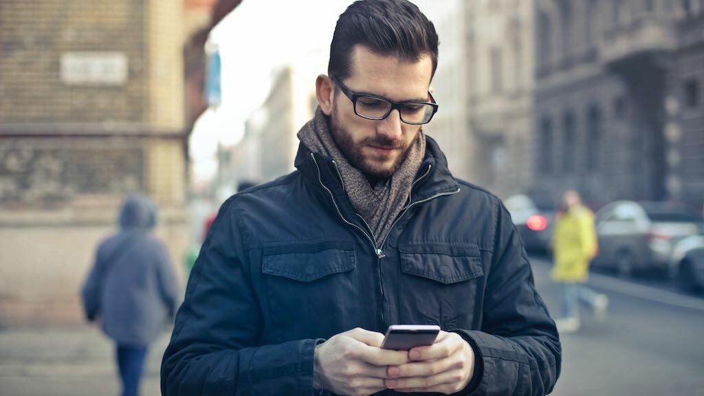 A man using a mobile phone to get local search results.